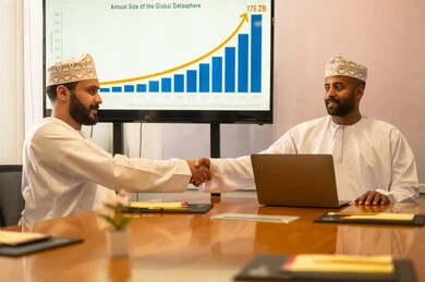 Conducting a job interview, successfully closing new business deals between businessmen, two Omani Arab Gulf men wearing traditional attire shaking hands, expanding business fields, partnership in business and engineering projects, studying statistical data, analyzing charts.
