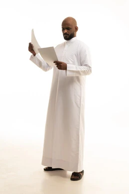 Expressions of thinking and concentration, scrutinizing the reading of notes, preparing work-related reports, a portrait of a Saudi Arabian Gulf man wearing traditional attire holding a set of documents and white papers in his hand, reviewing and following up on plans and projects with gestures of happiness and joy, white background.