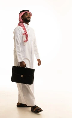 مفهوم ادارة الاعمال والمشاريع، المشي والذهاب الى مكان ما، الاهتمام بالمظهر الخارجي والأناقة، بورتريه لرجل أعمال عربي خليجي سعودي مبتسم يرتدي الثوب التقليدي والشماغ يحمل بيده حقيبة جلد سوداء ينظر إلى الكاميرا بإيماءات البشاشة والسرور، صورة الجسم بالطول الكامل، خلفية بيضاء مفهوم ادارة الاعمال والمشاريع، المشي والذهاب الى مكان ما، الاهتمام بالمظهر الخارجي والأناقة، بورتريه لرجل أعمال عربي خليجي سعودي مبتسم يرتدي الثوب التقليدي والشماغ يحمل بيده حقيبة جلد سوداء ينظر إلى الكاميرا بإيماءات البشاشة والسرور، صورة الجسم بالطول الكامل، خلفية بيضاء
