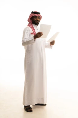 التدقيق في قراءة الملاحظات، تعابير التفكير والتركيز، اعداد التقارير الخاصة بالعمل، بورتريه لرجل عربي خليجي سعودي يرتدي الزى التقليدي والشماغ يحمل بيده مجموعة من الوثائق والاوراق البيضاء، مراجعة ومتابعة الخطط والمشاريع بإيماءات السعادة والسرور، خلفية بيضاء
