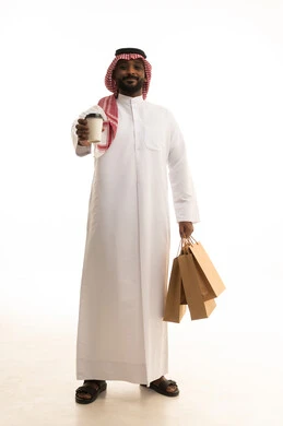 الاستمتاع بالمشروبات الساخنه ، عملية شحن وتوصيل موثوقه, خدمات التوصيل السريع, طلب وإستلام الدليفري, بورتريه لرجل عربي سعودي خليجي يرتدي الزى التقليدي والشماغ يمسك بيده كوب من القهوة يعمل في توصيل الطلبات والبضائع للزبائن, التسوق الالكتروني وطلبات اونلاين, خلفيه بيضاء