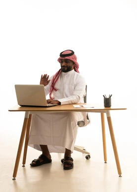 The concept of electronic marketing, professions and jobs in Saudi Arabia, holding a business meeting via laptop, a portrait of a Saudi Gulf Arab man wearing traditional attire and a ghutrah using a laptop, browsing social media, using modern technological devices, working remotely, white background.