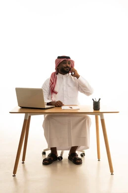 Using modern technology devices, remote work, displaying a blank black screen, holding a business meeting via laptop, a portrait of a Saudi Gulf Arab man wearing traditional attire and a ghutrah using a laptop, browsing social media, white background.