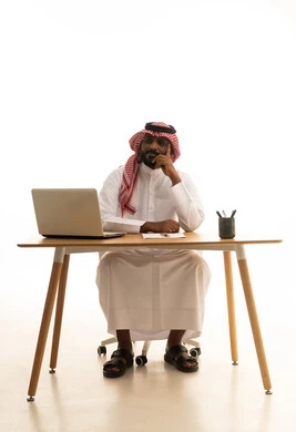 The concept of electronic marketing, professions and jobs in Saudi Arabia, holding a business meeting via laptop, a portrait of a Saudi Gulf Arab man wearing traditional attire and a ghutrah using a laptop, browsing social media, using modern technological devices, working remotely, white background.