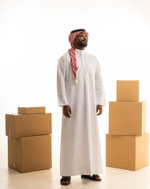 صناديق وحاويات كرتونية، ترتيب وتنظيم المنزل، بورتريه لرجل عربي خليجي سعودي يرتدي الزى التقليدي والشماغ  يقوم  بنقل صناديق الأغراض المنزلية، امتلاك سكن جديد والاستقرار العائلي، اسكان وتمليك حديث ، صورة الجسم بالطول الكامل، خلفية بيضاء