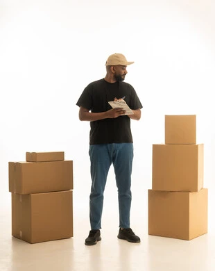 Modern housing and ownership, home delivery services, home organization and arrangement, a portrait of a Saudi Gulf Arab man wearing casual attire delivering boxes of household items while holding a notebook, owning a new home and family stability, full-body image, white background.