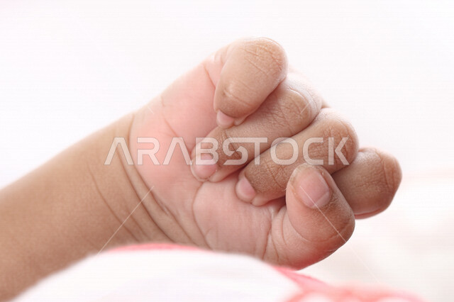 صورة ليد طفل رضيع مقبوضة , فهم لغة الجسد والإشارة والتعبير عنها , علامات جوع الطفل الرضيع واحتياجاته .