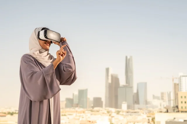 الاستمتاع في قضاء اوقات ترفيهية، تقنيات حديثة الكترونية وأجهزة تكنولوجية، التفاعل ومحاكاة العالم الافتراضي الخيالي, امرأة عربية خليجية سعودية محجبة تضع نظارات الفي ار, قضاء وقت ممتع خارج المنزل