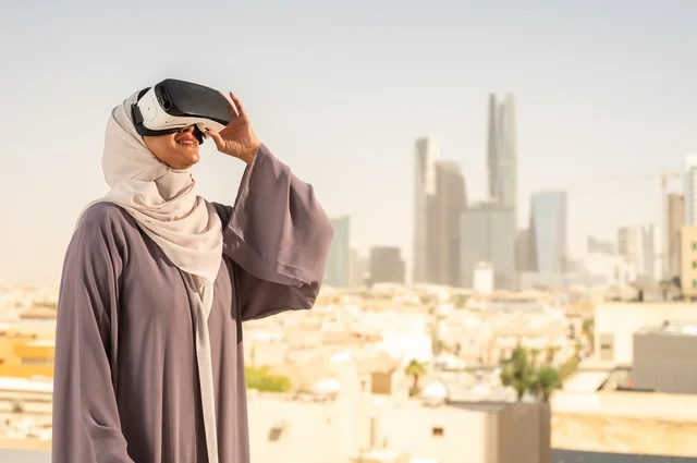 الاستمتاع في قضاء اوقات ترفيهية، تقنيات حديثة الكترونية وأجهزة تكنولوجية، التفاعل ومحاكاة العالم الافتراضي الخيالي, امرأة عربية خليجية سعودية محجبة تضع نظارات الفي ار, قضاء وقت ممتع خارج المنزل