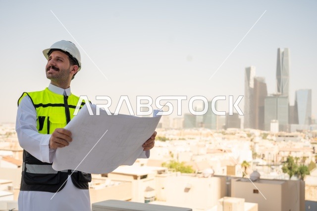 Accomplishing daily tasks to follow up on the progress of projects and their implementation, the concept of engineering project management, a side view of a Saudi Arabian Gulf engineer wearing traditional clothing, a special jacket and a protective helmet, holding and reading an engineering drawing, a background of towers and skyscrapers in Riyadh