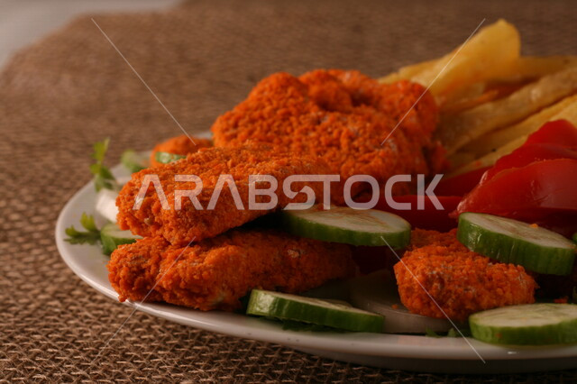 طبق من الدجاج المقرمش المغلف بالبقسماط ، قطع الدجاج المقلي ، دجاج بروست اللذيذ ، بطاطس مقلية  ، وجبات سريعة ساخنة 