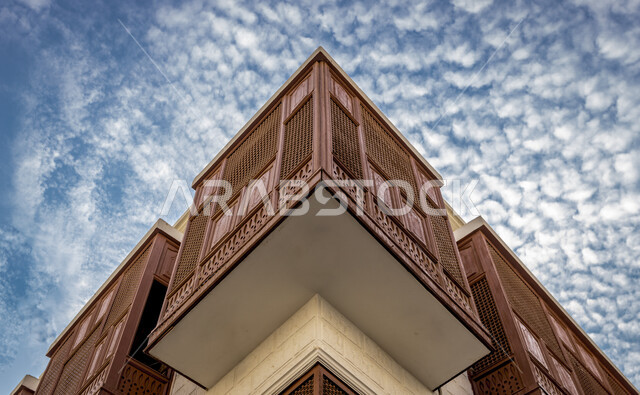 صورة من الاسفل للمباني التاريخيه الاثريه في جده البلد, التصاميم الهندسيه المعماريه العربيه, منظر السماء الزرقاء مع الغيوم البيضاء, معالم ومناطق تراثيه سياحيه في السعوديه