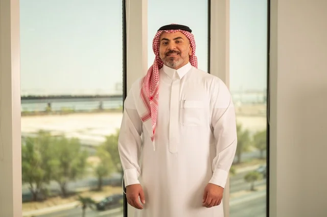 Pride and honor in the Saudi state, towers and skyscrapers of Riyadh, close-up of a Saudi Arabian Gulf man wearing the traditional thobe and shemagh standing straight with gestures of pleasure, progress and architectural development in the Gulf states
