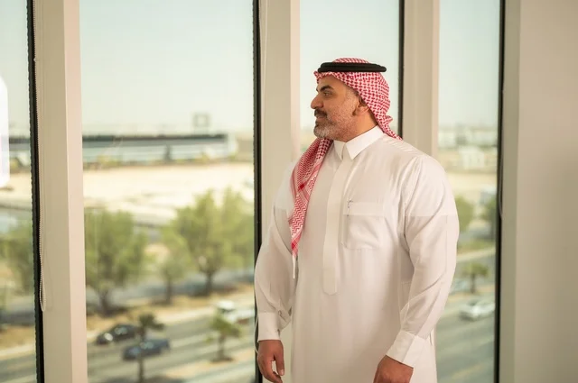 الفخر والاعتزاز بالدولة السعودية، أبراج وناطحات سحاب مدينة الرياض، رجل عربي خليجي سعودي يرتدي الثوب والشماغ التقليدي يقف باستقامة بايماءات السرور، التقدم والتطور المعماري في دول الخليج