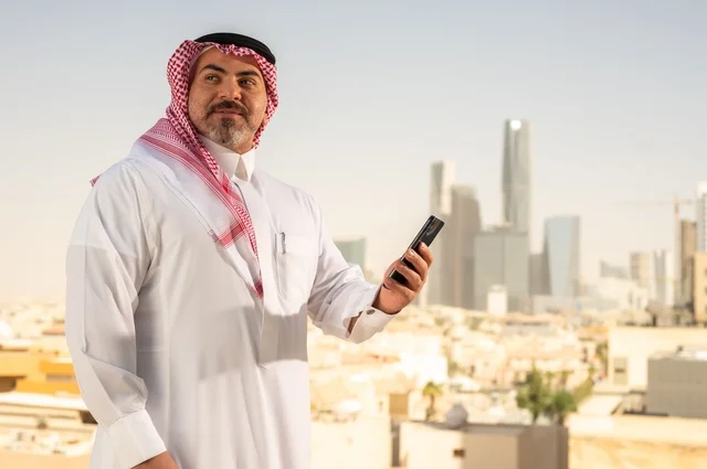 تصفح مواقع التواصل الاجتماعي، جهاز تقني حديث ومتطور، رجل عربي خليجي سعودي يرتدي الثوب والشماغ التقليدي يقوم باستخدام الهاتف المحمول، إنجاز العمل عن بعد، خلفية الأبراج وناطحات السحاب في مدينة الرياض تصفح مواقع التواصل الاجتماعي، جهاز تقني حديث ومتطور، رجل عربي خليجي سعودي يرتدي الثوب والشماغ التقليدي يقوم باستخدام الهاتف المحمول، إنجاز العمل عن بعد، خلفية الأبراج وناطحات السحاب في مدينة الرياض