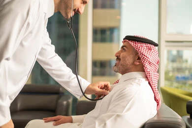 قياس  معدل ضربات القلب, مفهوم الطب والرعاية الصحية, المتابعة الدورية لفحص نبضات القلب, طبيب عربي خليجي سعودي يرتدي المعطف الطبي يقوم باستخدام سماعه الفحص الطبية لمريض كبير بالسن