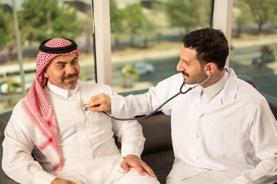 قياس  معدل ضربات القلب, مفهوم الطب والرعاية الصحية, المتابعة الدورية لفحص نبضات القلب, طبيب عربي خليجي سعودي يرتدي المعطف الطبي يقوم باستخدام سماعه الفحص الطبية لمريض كبير بالسن