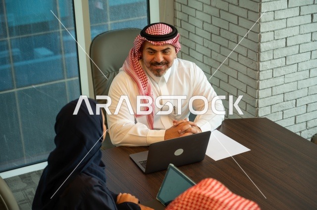 Workshops and training, exchanging experiences and ideas, studying and analyzing new projects, using modern technical devices, unity and teamwork, developing work and solving problems, holding a meeting for a team of Saudi Gulf Arab workers inside the company headquarters, a Saudi office profession and job.