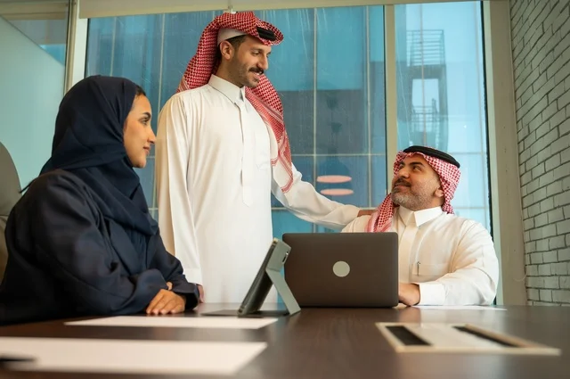 Using modern technical devices, unity and teamwork, developing work and problem-solving, holding a meeting for a team of Saudi Gulf Arab workers inside the company headquarters, studying and analyzing new projects, workshops and training, using modern technical devices, a Saudi office profession and job.