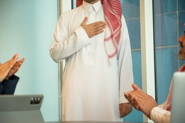 Welcoming new employees, greeting and saluting, using modern technical devices, a Saudi office profession and job, unity and teamwork, developing work and solving problems, holding a meeting for a team of Saudi Gulf Arab employees within the company premises, studying and analyzing new projects, conducting a job interview.