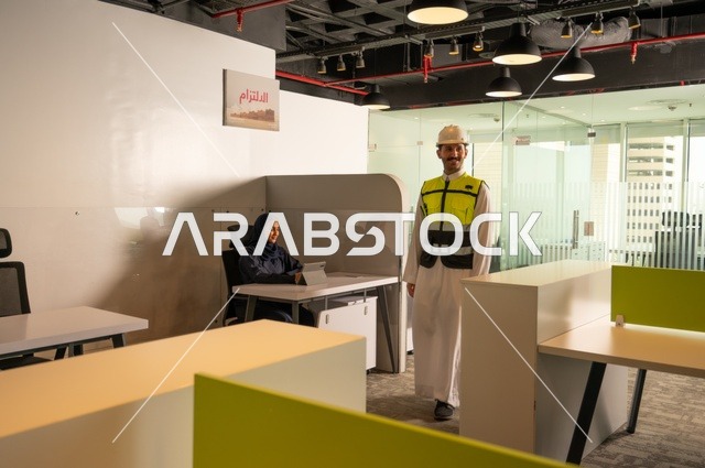 دراسة وتحليل المشاريع الجديدة، استخدام جهاز تقني حديث، الوحدة والعمل الجماعي، تطوير العمل وحل المشكلات، مهندس عربي خليجي سعودي يرتدي سترة العمل وخوذة الحماية داخل مقر الشركة، ورش عمل وتدريب، مهنة ووظيفة سعودية مكتبية، تبادل الخبرات والافكار