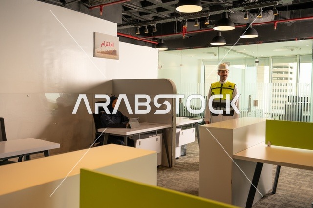 تطوير العمل وحل المشكلات، دراسة وتحليل المشاريع الجديدة، الوحدة والعمل الجماعي، صورة  لمهندس عربي خليجي سعودي يرتدي سترة العمل وخوذة الحماية داخل مقر الشركة، ورش عمل وتدريب، مهنة ووظيفة سعودية مكتبية، تبادل الخبرات والافكار