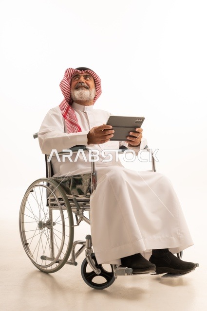 Utilizing modern techniques and advanced technology, providing devices and equipment that assist with movement and mobility, impaired motor ability, portrait of a Saudi Arabian Gulf man with special needs wearing traditional thobe and shemagh sitting in a wheelchair and holding a tablet in his hand, white background