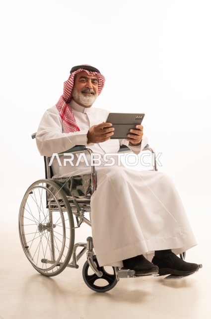 Utilizing modern techniques and advanced technology, providing devices and equipment that assist with movement and mobility, impaired motor ability, portrait of a Saudi Arabian Gulf man with special needs wearing traditional thobe and shemagh sitting in a wheelchair and holding a tablet in his hand, white background