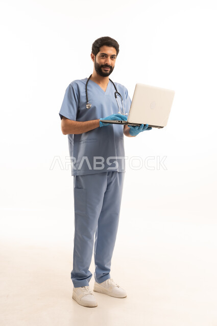 دمح التكنولوجيا في المجال الطبي، مفهوم الطب والرعاية الصحية، بورتريه لممرص عربي خليجي سعودي يرتدي اليونيفورم مع السماعة الطبية يقدم الخدمات للمرضى ويحمل بيده الحاسوب المحمول، مهنة ووظيفة طبية، العمل في القطاع الصحي في المملكة، الجسم بالطول الكامل، خلفيه بيضاء
