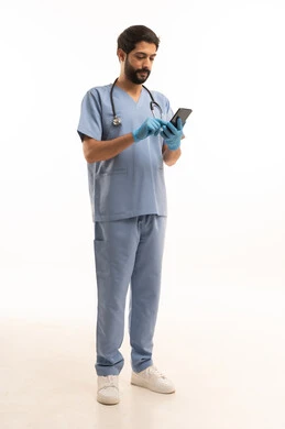 تقديم الخدمات الصحية للمرضى في المراكز والمستشفيات، مفهوم الطب والرعاية الصحية، بورتريه لممرض عربي خليجي سعودي يرتدي اليونيفورم مع السماعة الطبية يحمل بيده الهاتف المحمول، مهنة ووظيفة طبية، العمل في القطاع الصحي في المملكة، الجسم بالطول الكامل، خلفيه بيضاء