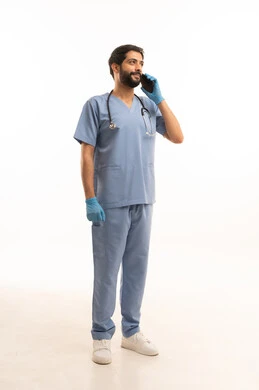 اجراء مكالمة هاتفية، تقديم الخدمات الصحية للمرضى، مفهوم الطب والرعاية الصحية، بورتريه لممرض عربي خليجي سعودي يرتدي اليونيفورم مع السماعة الطبية يحمل بيده الهاتف المحمول، مهنة ووظيفة طبية، العمل في القطاع الصحي في المملكة، الجسم بالطول الكامل، خلفيه بيضاء