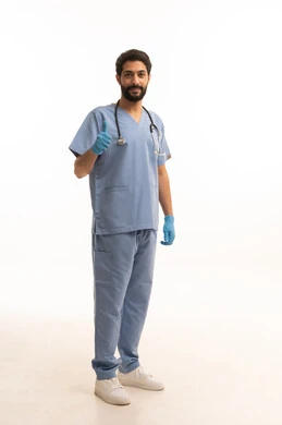 رفع اصبع الابهام بايماءات الاعجاب والرضى، مفهوم الطب والرعاية الصحية، بورتريه لممرض عربي خليجي سعودي يرتدي اليونيفورم مع السماعة الطبية يقدم الخدمات الصحية للمرضى، مهنة ووظيفة طبية، العمل في القطاع الصحي في المملكة، الجسم بالطول الكامل، خلفيه بيضاء