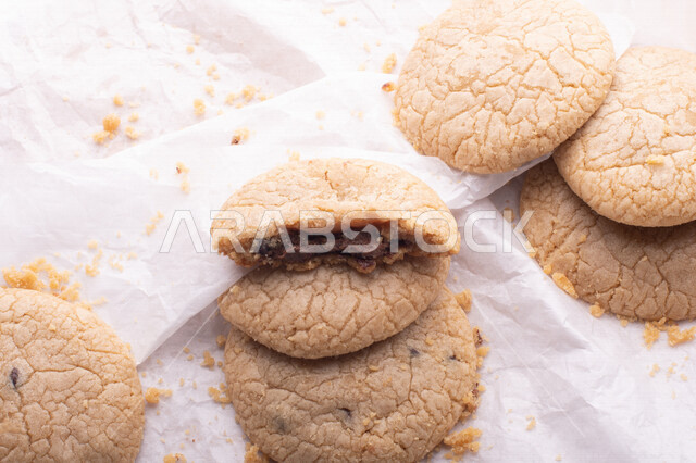 صورة لقطع من البسكويت المقرمش متناثر على خلفية بيضاء , قطع البسكويت المحشوة بقطع الشوكولاتة  . 