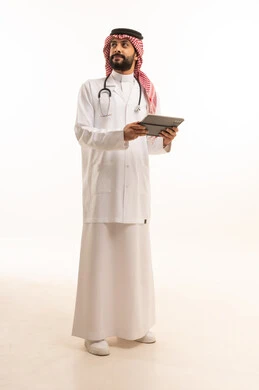 استخدام الجهاز اللوحي، مفهوم الطب والرعاية الصحية، بورتريه لطبيب عربي خليجي سعودي يرتدي الثوب التقليدي مع المعطف والسماعة يقدم الخدمات الصحية للمرضى في المراكز والمستشفيات، مهنة ووظيفة طبية، العمل في القطاع الصحي في المملكة، الجسم بالطول الكامل، خلفيه بيضاء