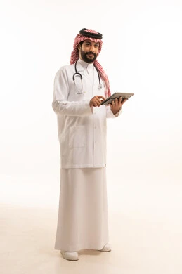 استخدام الجهاز اللوحي، مفهوم الطب والرعاية الصحية، بورتريه لطبيب عربي خليجي سعودي يرتدي الثوب التقليدي مع المعطف والسماعة يقدم الخدمات الصحية للمرضى في المراكز والمستشفيات، مهنة ووظيفة طبية، العمل في القطاع الصحي في المملكة، الجسم بالطول الكامل، خلفيه بيضاء