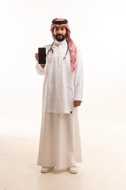 عرض شاشة سوداء فارغة عبر الهاتف المحمول، مفهوم الطب والرعاية الصحية، بورتريه لطبيب عربي خليجي سعودي يرتدي الثوب التقليدي مع المعطف والسماعة الطبية يقدم الخدمات الصحية للمرضى، مهنة ووظيفة طبية، العمل في القطاع الصحي في المملكة، الجسم بالطول الكامل، خلفيه بيضاء