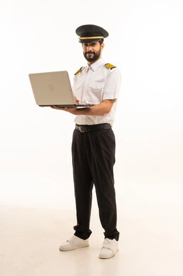 طاقم الاستقبال والترحيب بالركاب، العمل في مجال الطيران، رحلات جوية سياحية, استخدام الحاسوب المحمول، مفهوم السياحة والسفر، خطوط الطيران السعودية, بورتريه لكابتن طيار عربي سعودي خليجي مبتسم يرتدي الزي الرسمي يقف باستقامة، الجسم بالطول الكامل، خلفيه بيضاء