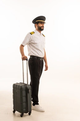 Blank black screen view on mobile phone, tourism and travel concept, welcome and reception crew, aviation work, tourist flights, Saudi Airlines, portrait of smiling Saudi Arabian Gulf Arab pilot in uniform pulling suitcase, full body, white background