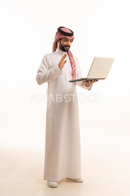 Managing and organizing business affairs through technical devices, an administrative profession and job, integrating work with technology, a portrait of a Saudi Arabian Gulf businessman wearing a traditional thobe and shemagh working on a laptop, using a modern and advanced technical device, working remotely and completing the required tasks
