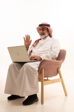 Managing and organizing business affairs through technical devices, an administrative profession and job, integrating work with technology, a portrait of a Saudi Arabian Gulf businessman wearing a traditional thobe and shemagh working on a laptop, using a modern and advanced technical device, working remotely and completing the required tasks