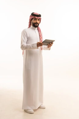 Working remotely and completing required tasks, managing and organizing business affairs through technical devices, an administrative profession and job, integrating work with technology, a portrait of a Saudi Arabian Gulf man wearing a traditional thobe and shemagh working on a tablet, using a modern and advanced technical device, a white background