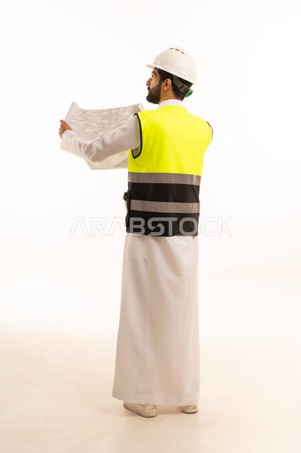 Working remotely and completing required tasks, managing and organizing business affairs through technical devices, an administrative profession and job, integrating work with technology, a portrait of a Saudi Arabian Gulf man wearing a traditional thobe and shemagh working on a tablet, using a modern and advanced technical device, a white background