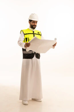 مشاريع إعمارية سعودية وطنية، مفهوم الهندسة المعمارية، متابعة مخطط المشروع الهندسي وتدقيقه, الاهتمام بالتطور العمراني بسواعد المهندسين السعوديين, بورتريه لمهندس عربي خليجي سعودي يرتدي سترة العمل وخوذة الحماية يحمل بيده المخطط، الجسم بالطول الكامل، خلفية بيضاء