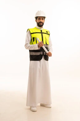 مشاريع إعمارية سعودية وطنية، مفهوم الهندسة المعمارية، متابعة مخطط المشروع الهندسي وتدقيقه, الاهتمام بالتطور العمراني بسواعد المهندسين السعوديين, بورتريه لمهندس عربي خليجي سعودي يرتدي سترة العمل وخوذة الحماية يحمل بيده المخطط، الجسم بالطول الكامل، خلفية بيضاء