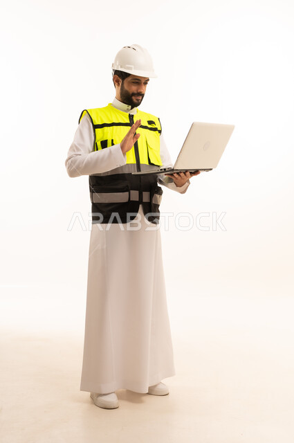 Using a modern and advanced technical device, Saudi national construction projects, the concept of architecture, interest in urban development by Saudi engineers, portrait of a Saudi Arabian Gulf engineer wearing a work jacket and a protective helmet, holding a laptop, full body, white background