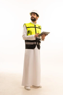 مفهوم الهندسة المعمارية، الاهتمام بالتطور العمراني بسواعد المهندسين السعوديين, استخدام جهاز تقني حديث ومتطور، مشاريع إعمارية سعودية وطنية، بورتريه لمهندس عربي خليجي سعودي يرتدي سترة العمل وخوذة الحماية يحمل بيده الجهاز اللوحي، الجسم بالطول الكامل، خلفية بيضاء