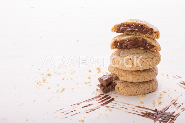 صورة لقطع من البسكويت المقرمش مصفوفة على طبقات , قطع البسكويت المحشوة بحشوة الشوكولاتة الذائبة . 