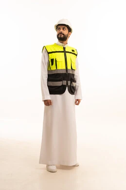 Working in the field of architecture, interest in urban development by the hands of Saudi engineers, Saudi national construction projects, portrait of a Saudi Arabian Gulf engineer wearing a work jacket and a protective helmet, standing straight with gestures of pleasure, full body, white background