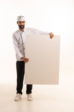 موك اب ابيض كبير, احتراف مهنة طهي الطعام السعودي, الوقوف باستقامة وتعابير السعادة, بورتريه لشيف عربي خليجي سعودي يرتدي يونيفورم الطبخ يمسك بيده لوحة بيضاء فارغة، الجسم بالطول الكامل, خلفية بيضاء