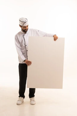 موك اب ابيض كبير, احتراف مهنة طهي الطعام السعودي, الوقوف باستقامة وتعابير السعادة, بورتريه لشيف عربي خليجي سعودي يرتدي يونيفورم الطبخ يمسك بيده لوحة بيضاء فارغة، الجسم بالطول الكامل, خلفية بيضاء